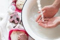 ChildÃ¢â¬â¢s hands under white bowl with water upon water stream Royalty Free Stock Photo